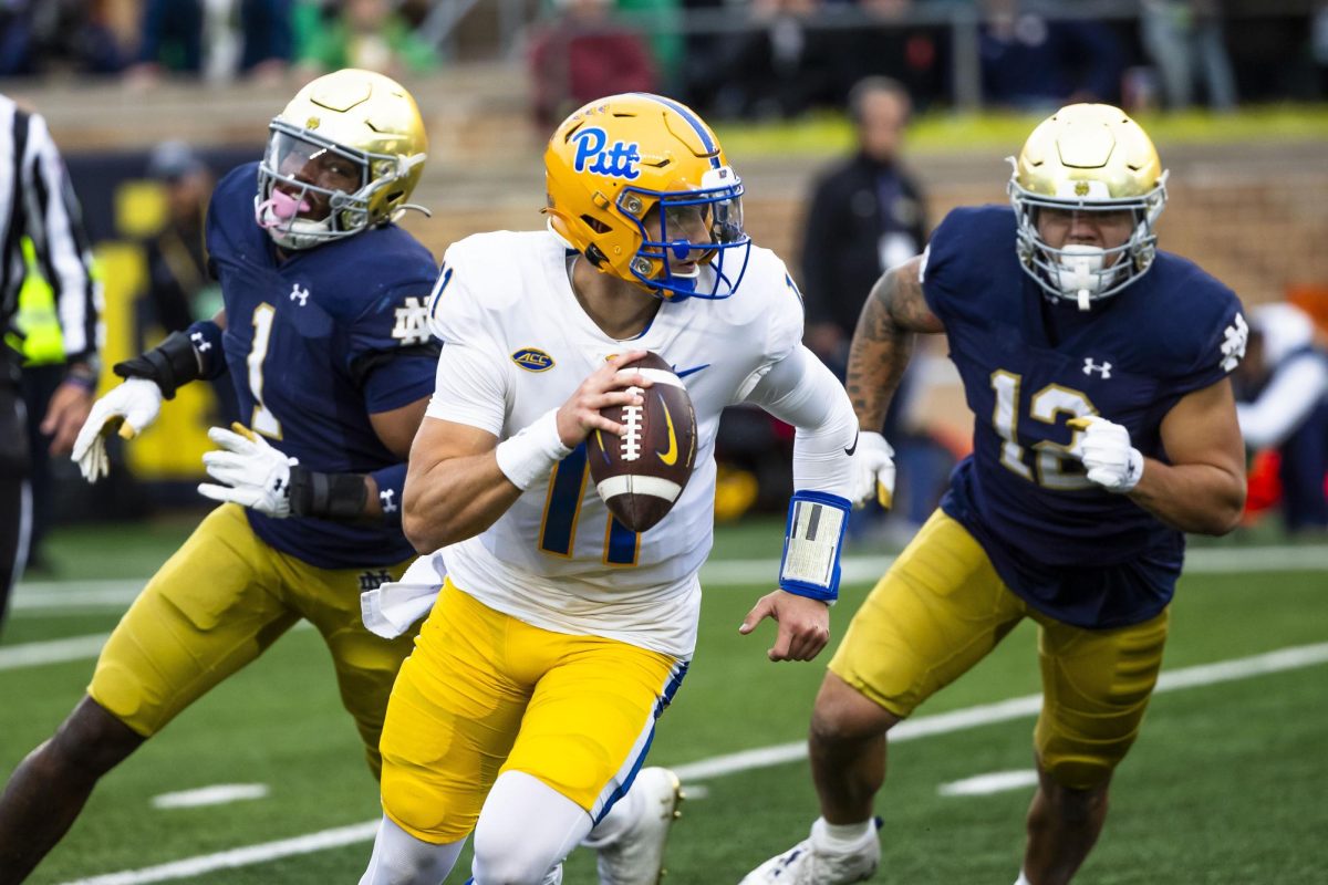Pittsburgh quarterback Christian Veilleux (11) runs away from Notre Dame defensive lineman Javontae Jean-Baptiste (1) and defensive lineman Jordan Botelho (12) during the second half of an NCAA college football game Saturday, Oct. 28, in South Bend, Ind.