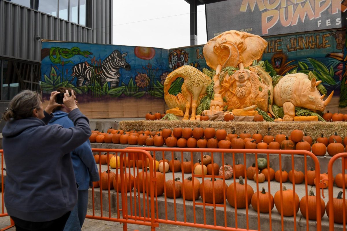 Festivalgoers photograph a pumpkin art piece on display at the Monster Pumpkin Festival in Pittsburgh’s Strip District on Saturday. 
