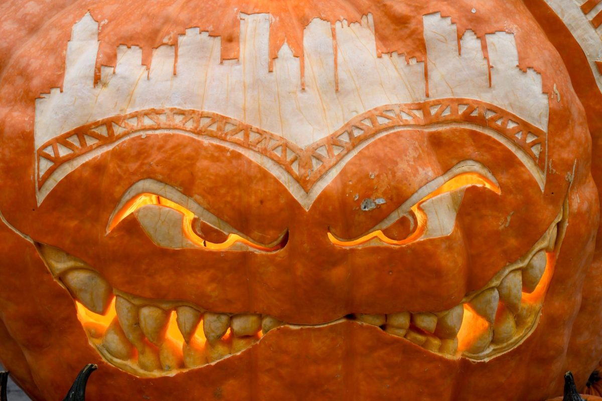 A giant jack-o’-lantern sits on display with the Pittsburgh skyline carved into the brow at the Monster Pumpkin Festival in the Strip District on Saturday.