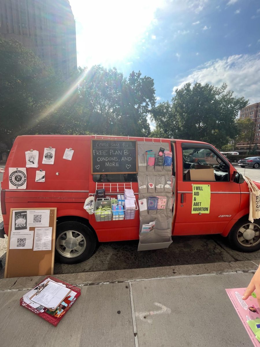 A van sits outside the Cathedral of Learning advertising free condoms and Plan B.