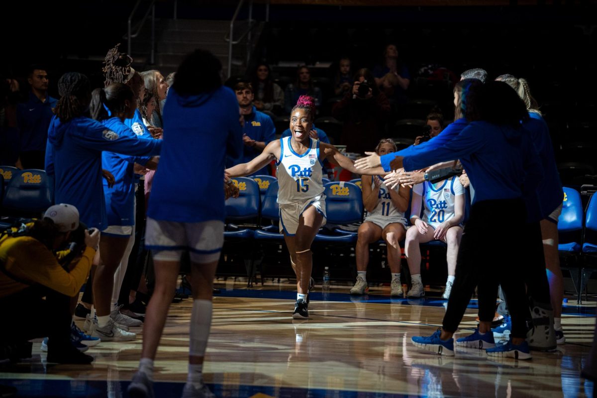 Junior Forward Rapuluchi Ayodele (15) high fives teammates while being introduced before Monday night’s exhibition game against Point Park in the Petersen Events Center.