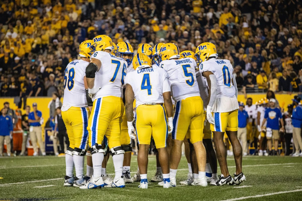 Pitt Football’s offense huddles before a play during the Backyard Brawl in Morgantown, West Virginia, on Saturday, Sept. 16.