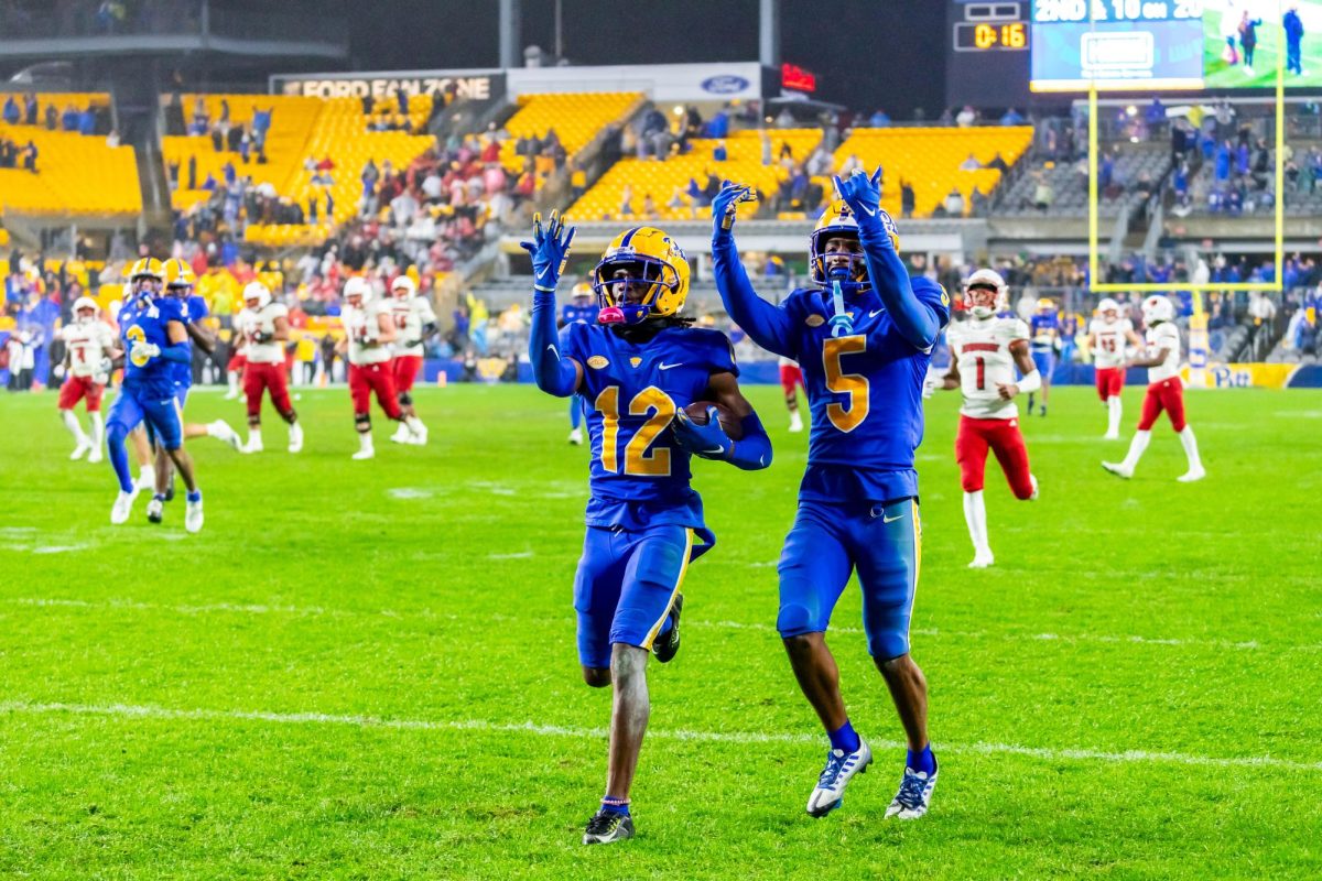 Redshirt Senior M.J. Devonshire (12) and Junior Phillip OBrien Jr. (5) celebrate in front of the Panther Pit during Saturday nights game against Louisville at Acrisure Stadium.