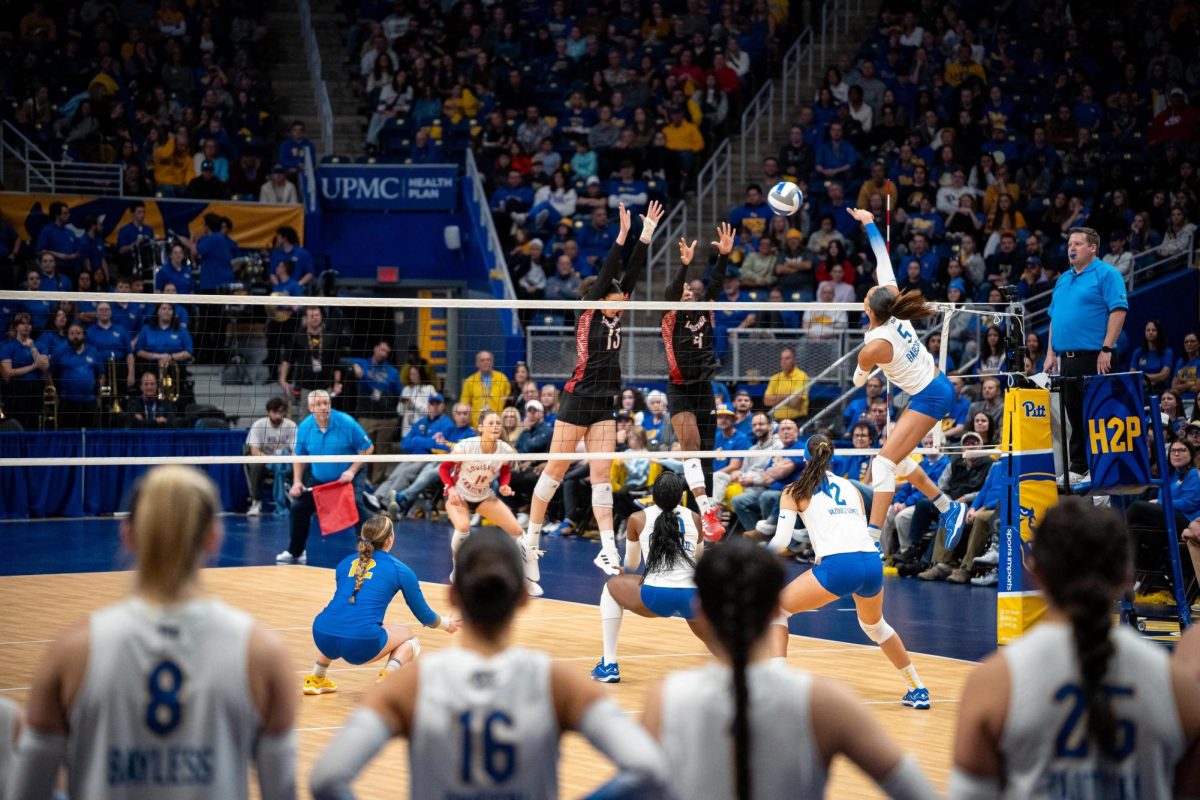 First-year opposite hitter Olivia Babcock (5) spikes the ball in front of a record-setting crowd during Saturday afternoons match against Louisville at the Petersen Events Center.