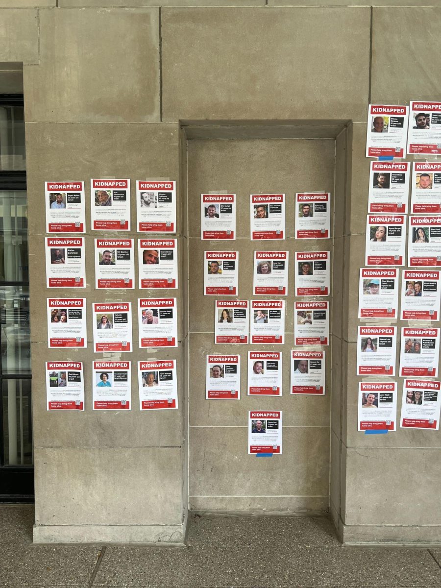 Posters of Israeli hostages being held by Hamas after its attack on Israel last month on the outside wall of Amos Hall in the Schenley Quadrangle.