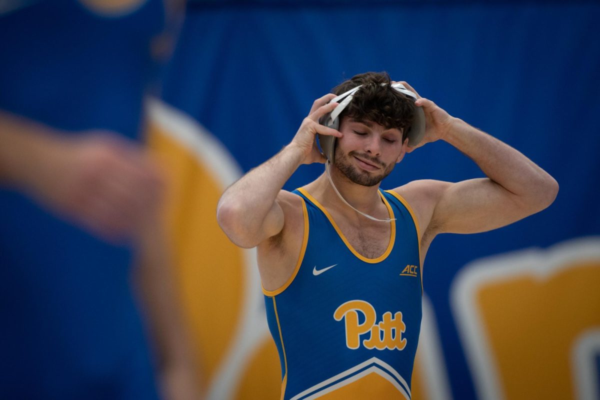 A Pitt wrestler takes off their headgear during the Blue-Gold Dual at the Fitzgerald Field House on Monday, Oct. 30.