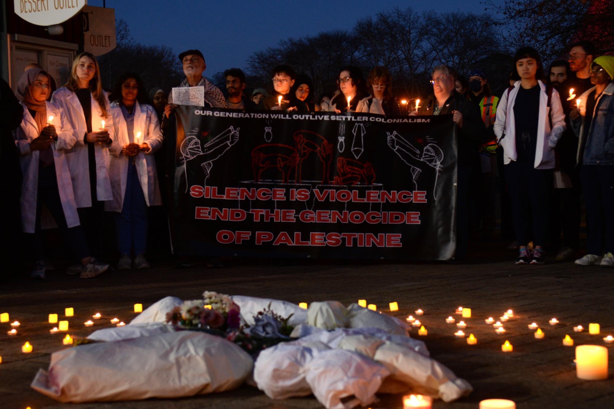 Healthcare workers and allies call for the re-entry of vital humanitarian aid and demand an immediate and permanent ceasefire in Gaza during a public vigil in Schenley Plaza on Friday. 