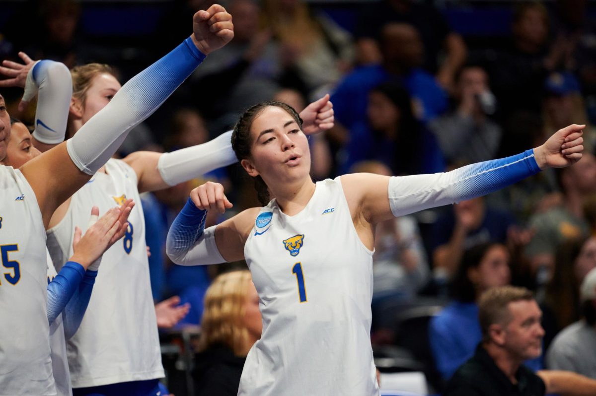 Graduate student setter Lexis Akeo (1) celebrates a point during Friday night’s volleyball match against Coppin State in the first round of the 2023 NCAA Tournament at the Petersen Events Center. 