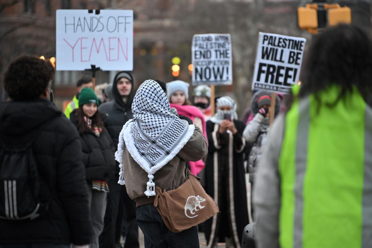 A woman wearing a keffiyeh speaks to protesters during Monday afternoon’s “Hands Off Yemen” protest in Schenley Plaza.