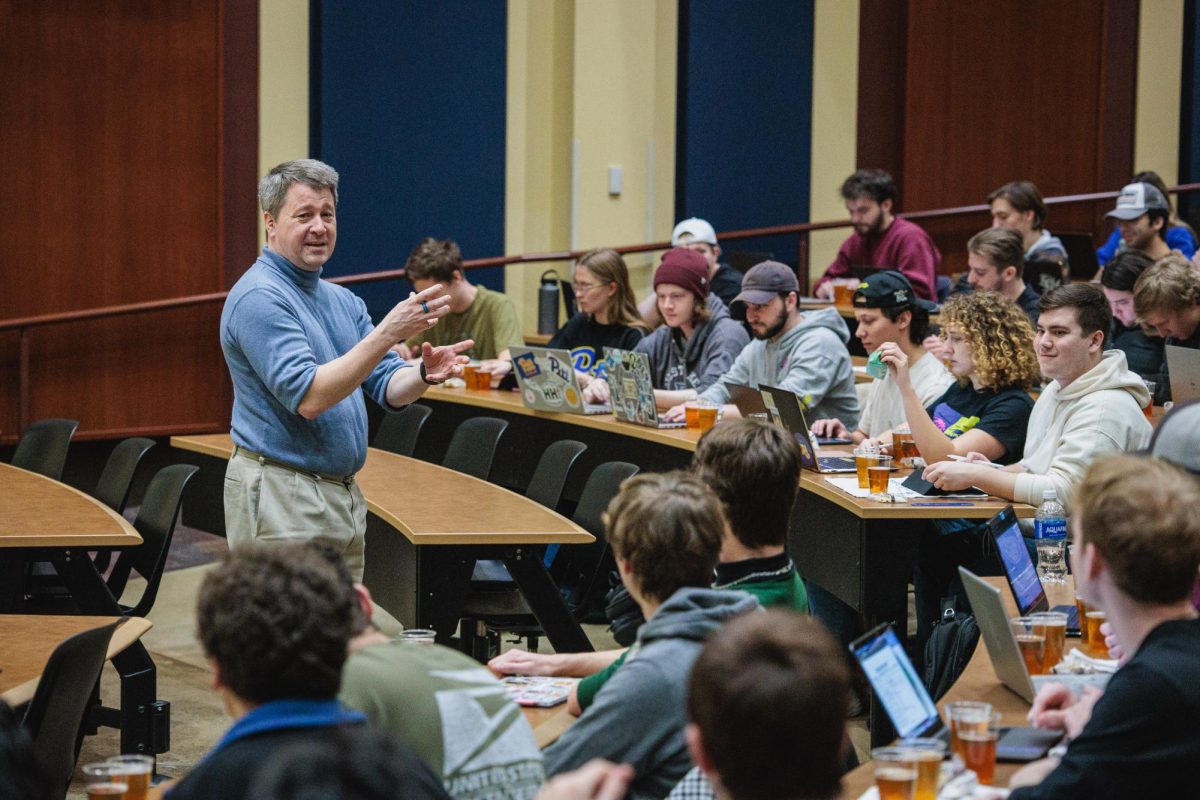 Bob Parker speaks to students before they begin reviewing beers during a class Friday in David Lawrence Hall.