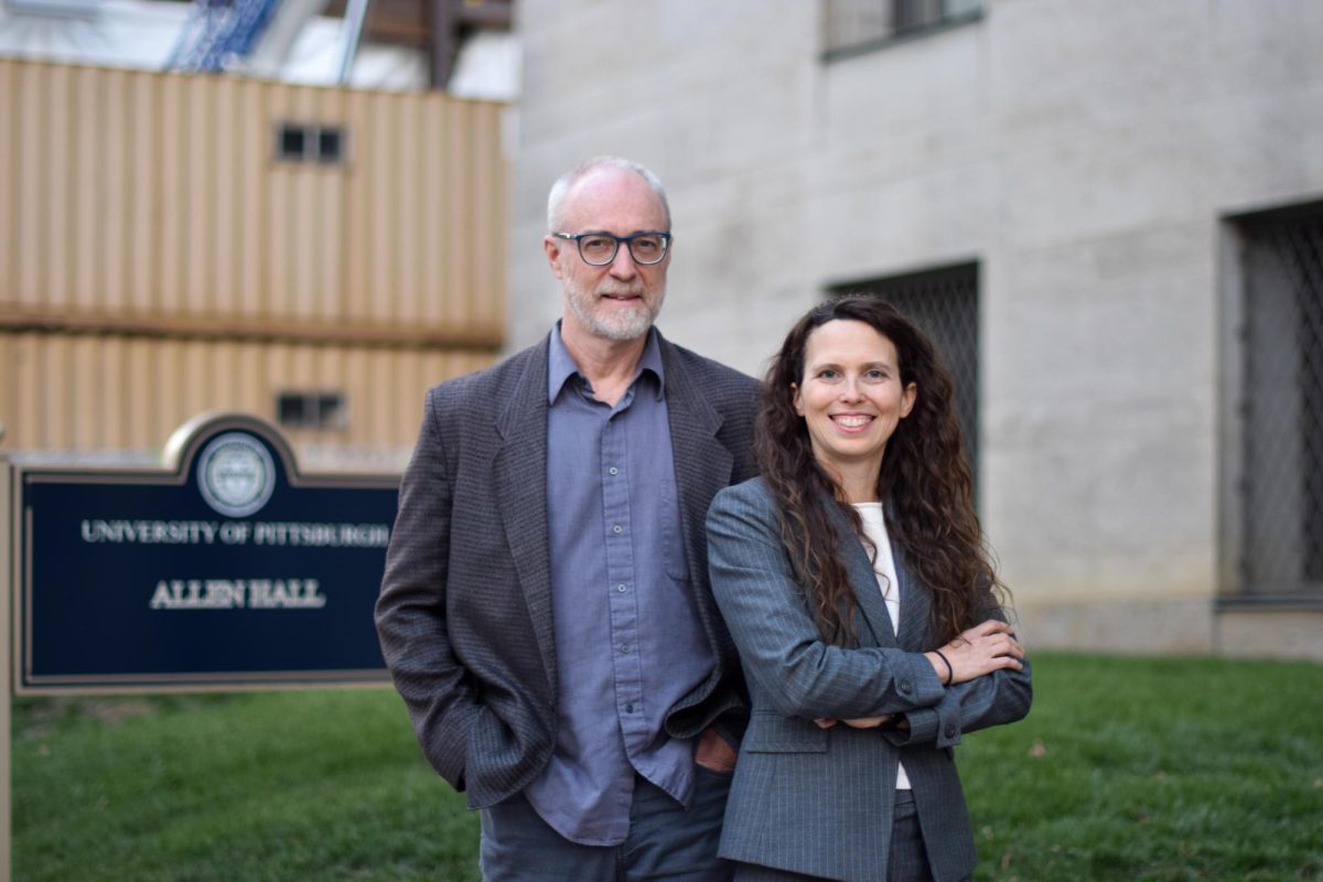 Melanie Good and Eric Swanson pose for a photo in front of Allen Hall.