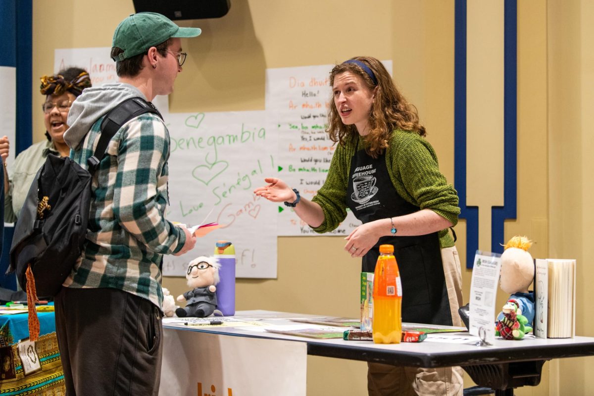Senior French and linguistics major Allison Schaeffer converses with an attendee at the Less-Commonly-Taught Languages Coffee House in the William Pitt Union on Friday afternoon.