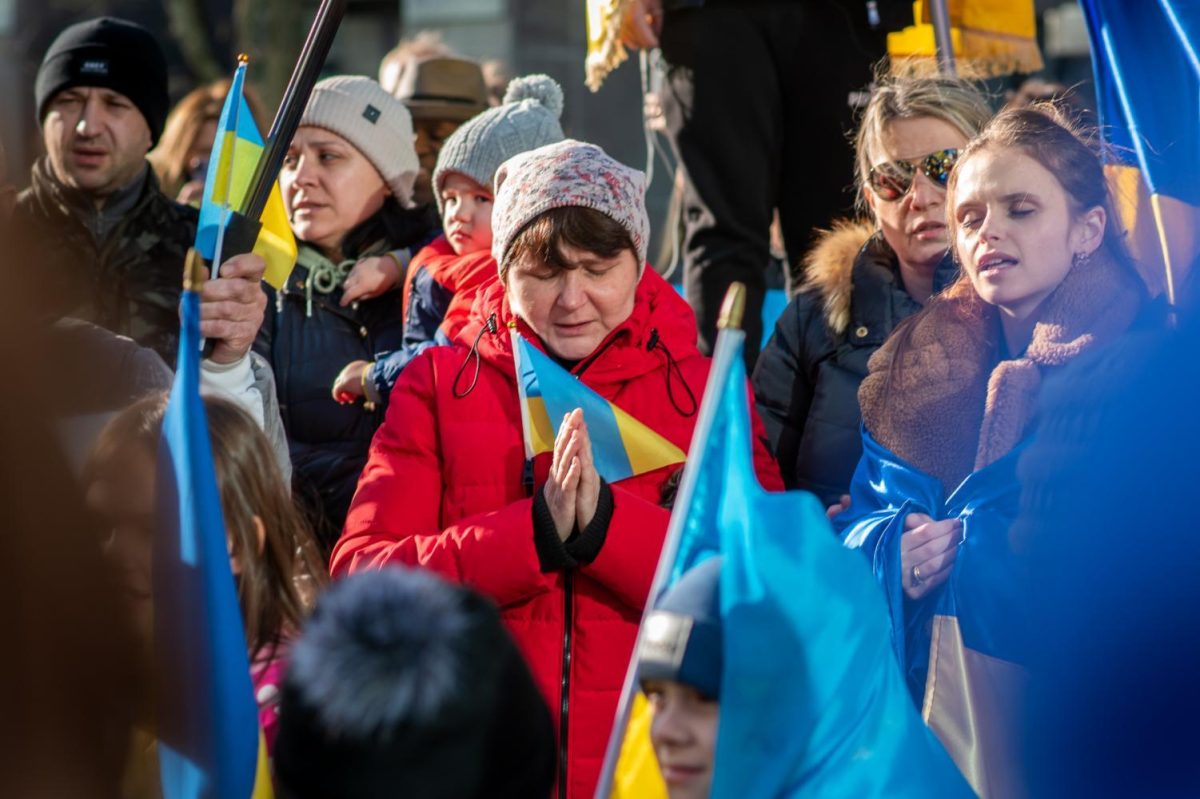 A woman prays during a rally Downtown in support of Ukraine on Feb. 27, 2022.
