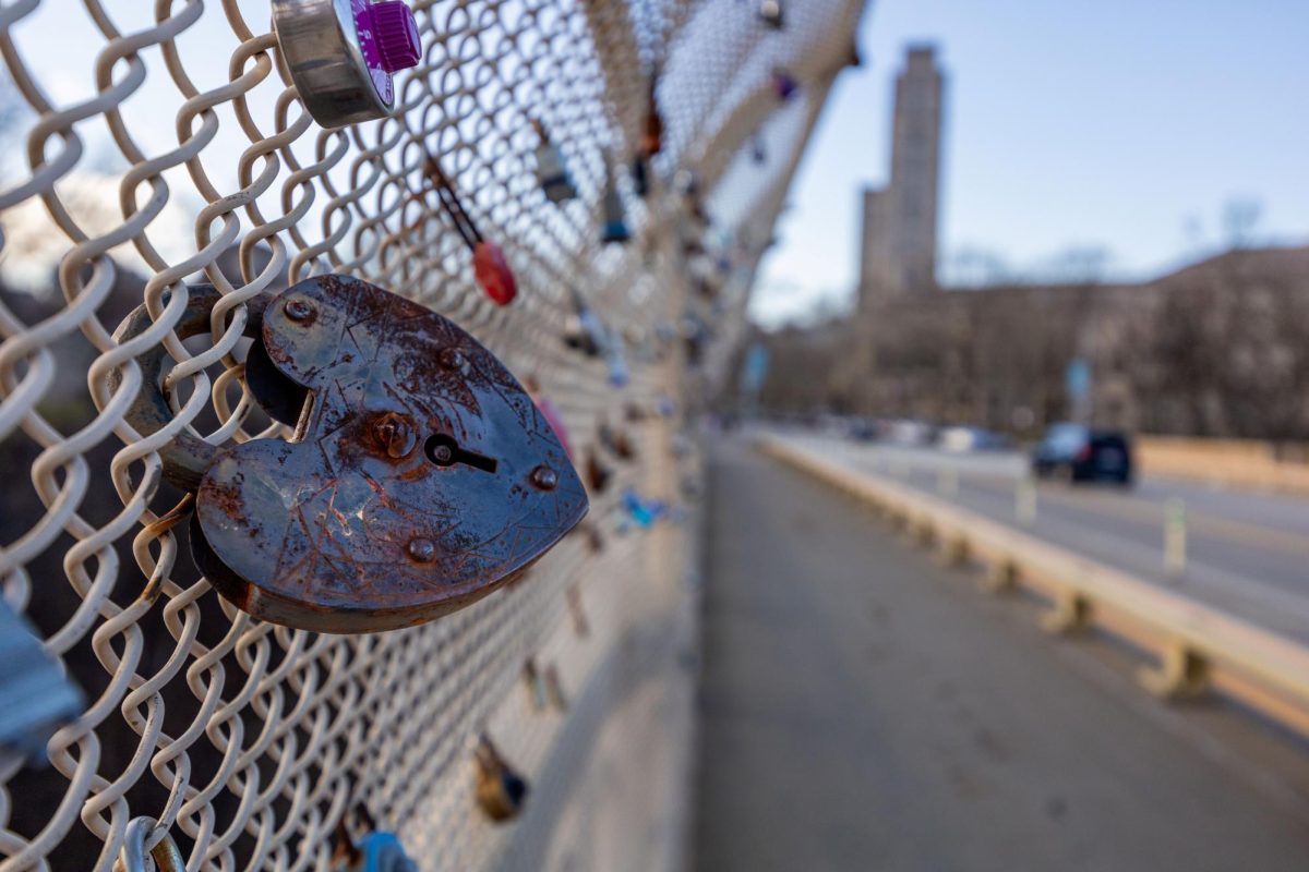 A heart shaped lock attached to the fencing of the Schenley Bridge.