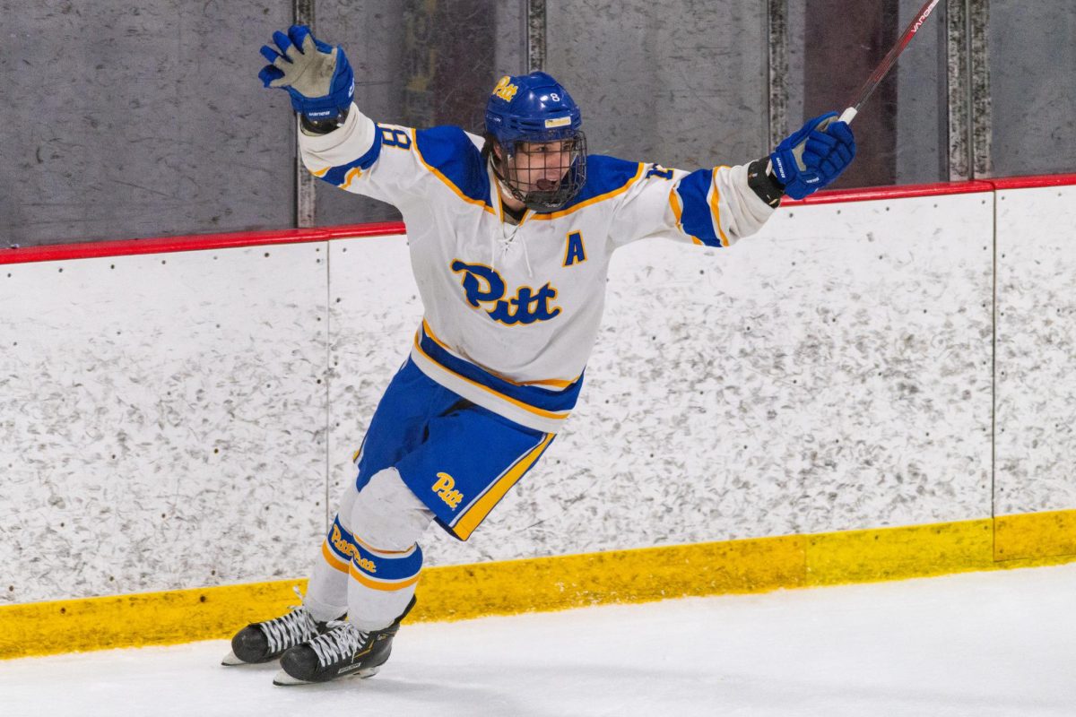 Senior center Jeffrey Bele (18) celebrates after scoring the second goal of Pitt Club Hockey’s final home game against Oswego on Saturday at Alpha Ice Complex.