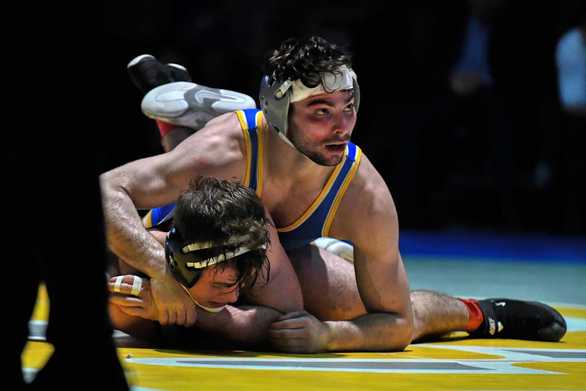 A Pitt wrestler pins their opponent during Friday evening’s meet against Virginia in the Fitzgerald Field House.