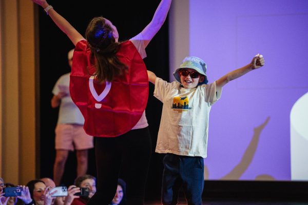 A student with Pitt Dance Marathon joins a miracle kid on stage during the fashion show in the William Pitt Union Assembly Room on Wednesday evening.