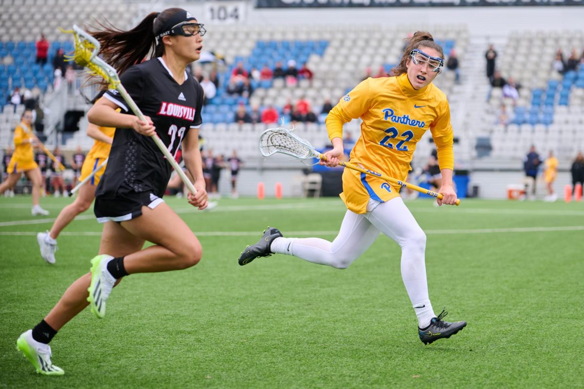 Senior midfielder Maureen McNierney (22) chases after a Louisville player during Saturday afternoon’s game at Highmark Stadium.