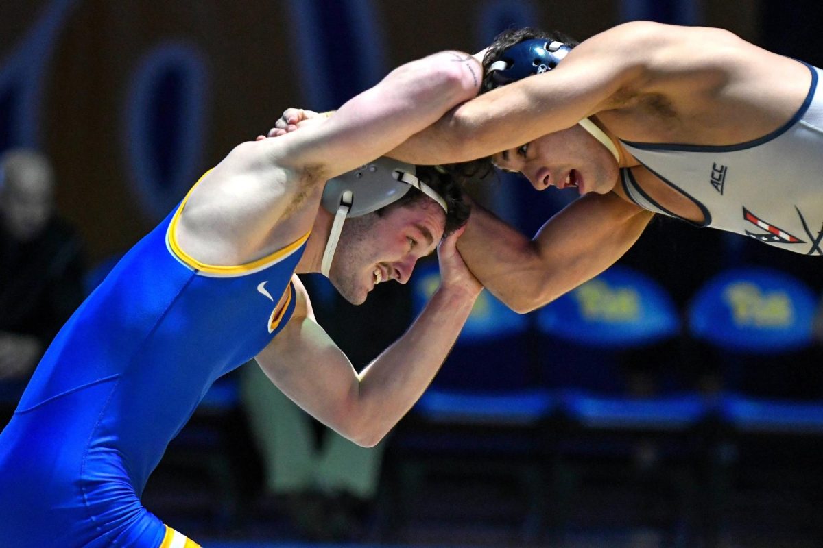 A Pitt wrestler fights for hand control during the meet against Virginia in the Fitzgerald Field House on Feb. 23.