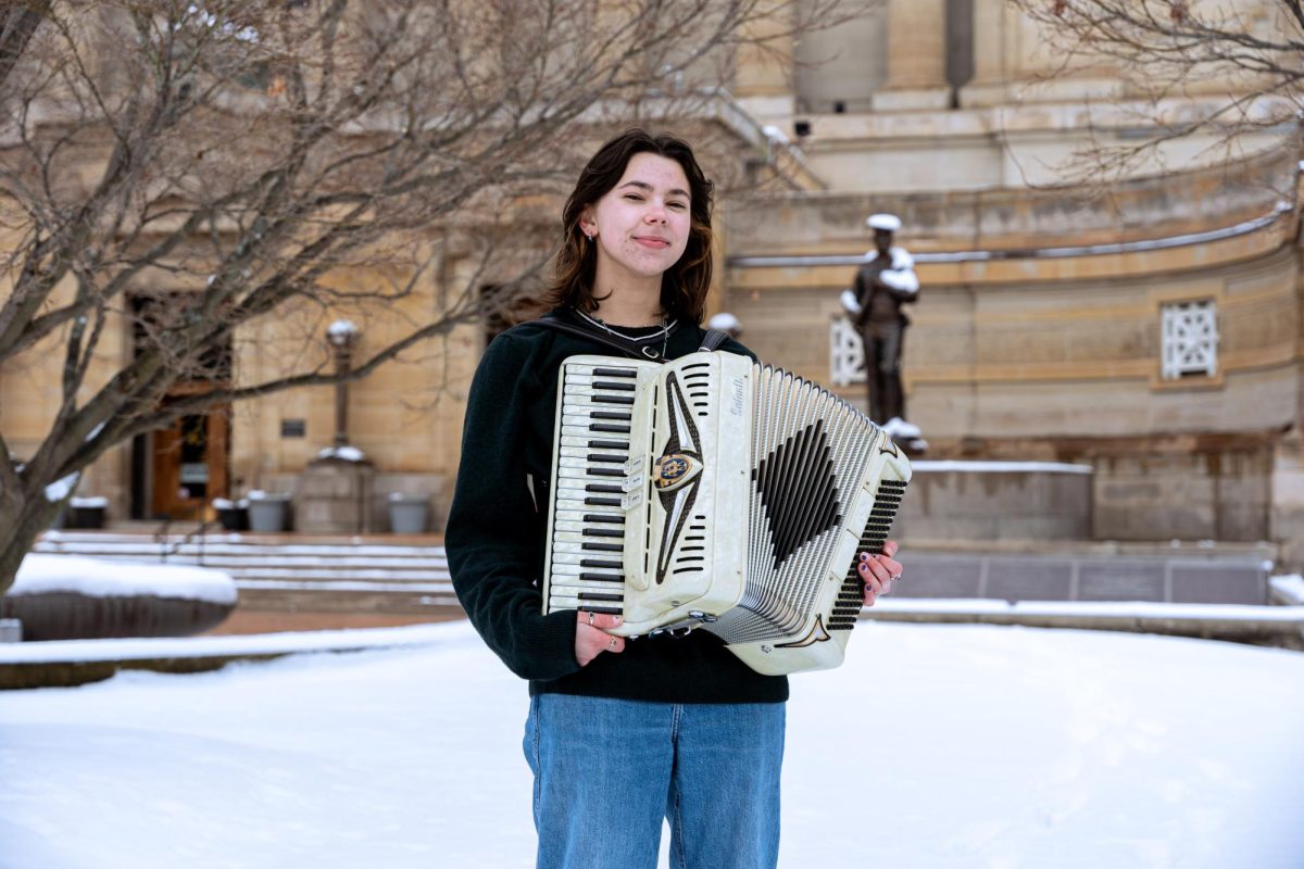 Alex Borg poses for a photo with an accordion on Soldiers and Sailors Lawn.