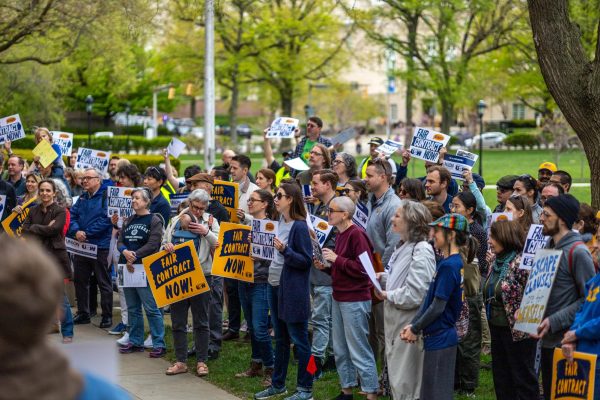Protestors hold signs in support of faculty unionization during a rally outside the chancellors office on Tuesday afternoon. 