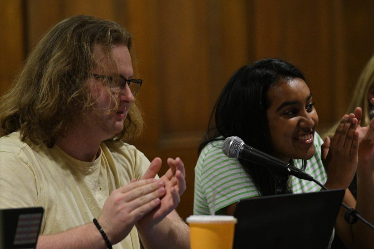Ryan Young, Student Government Board president, and Sarah Siddiqui, vice president of operations, applaud the approval of an allocations request during the public meeting in Nordy’s Place on Tuesday. 