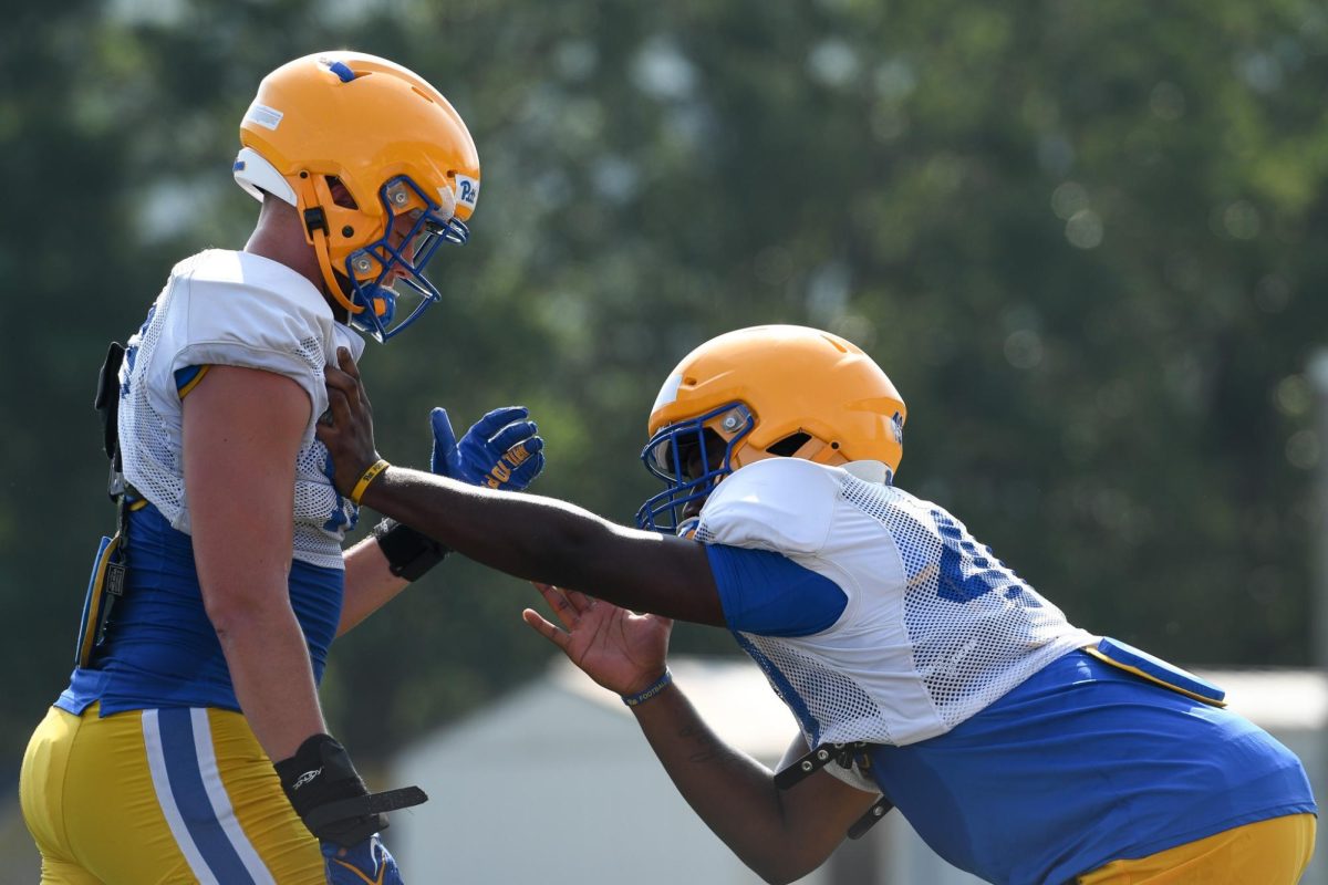 Pitt football players practice defensive tactics at summer training camp at the UPMC Rooney Sports Complex.
