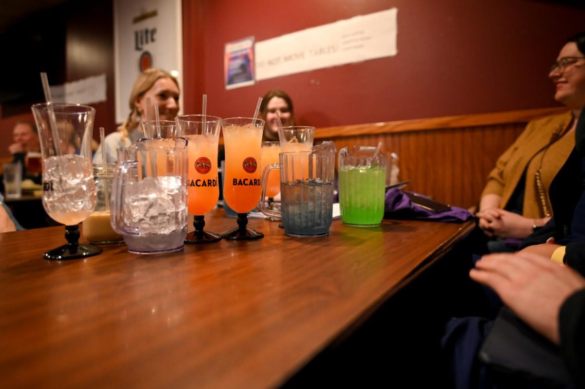 People sit around a table with pitchers of drinks at Hemingway’s.