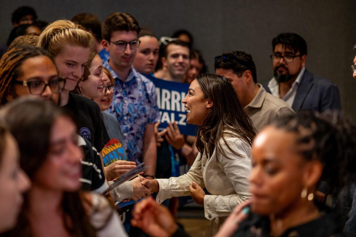 United States Representative Alexandria Ocasio-Cortez shakes the hand of a “Students for Harris-Walz” rally attendee at Carnegie Mellon University on Sunday.