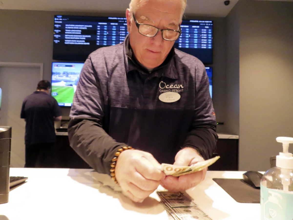 A worker at the sports book in the Ocean Casino Resort counts money on Feb. 6, 2023, in Atlantic City, N.J.