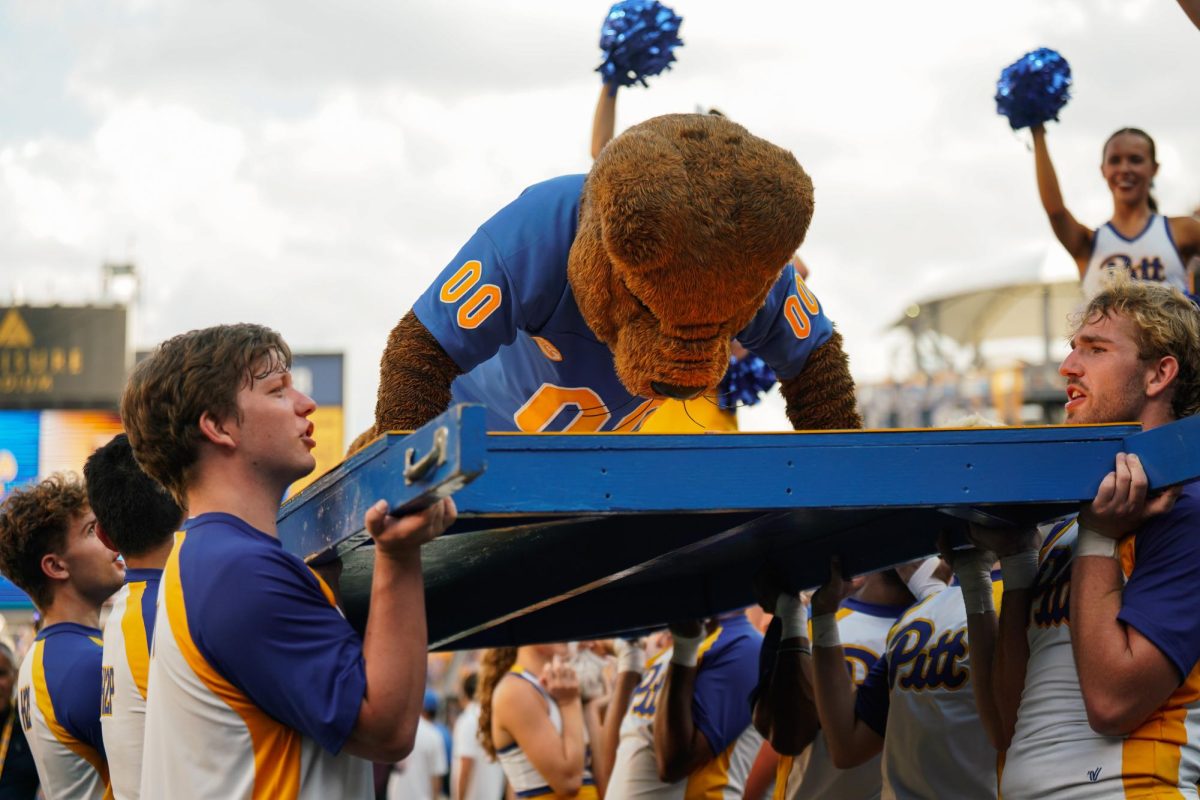 Roc the Panther does push-ups while being held by Pitt cheerleaders at the football game against Youngstown State at Acrisure Stadium on Saturday.