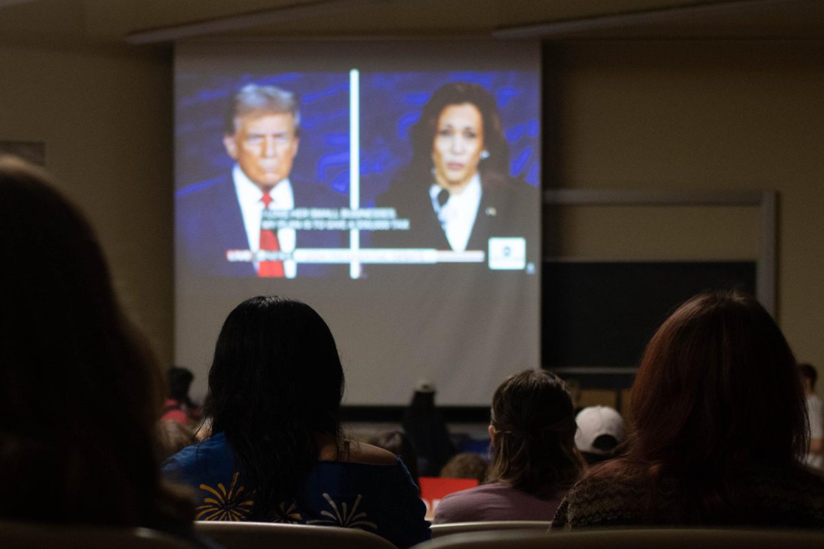 Students watch the debate between Vice President Kamala Harris and former President Donald Trump during the College Democrats debate watch party on Tuesday.