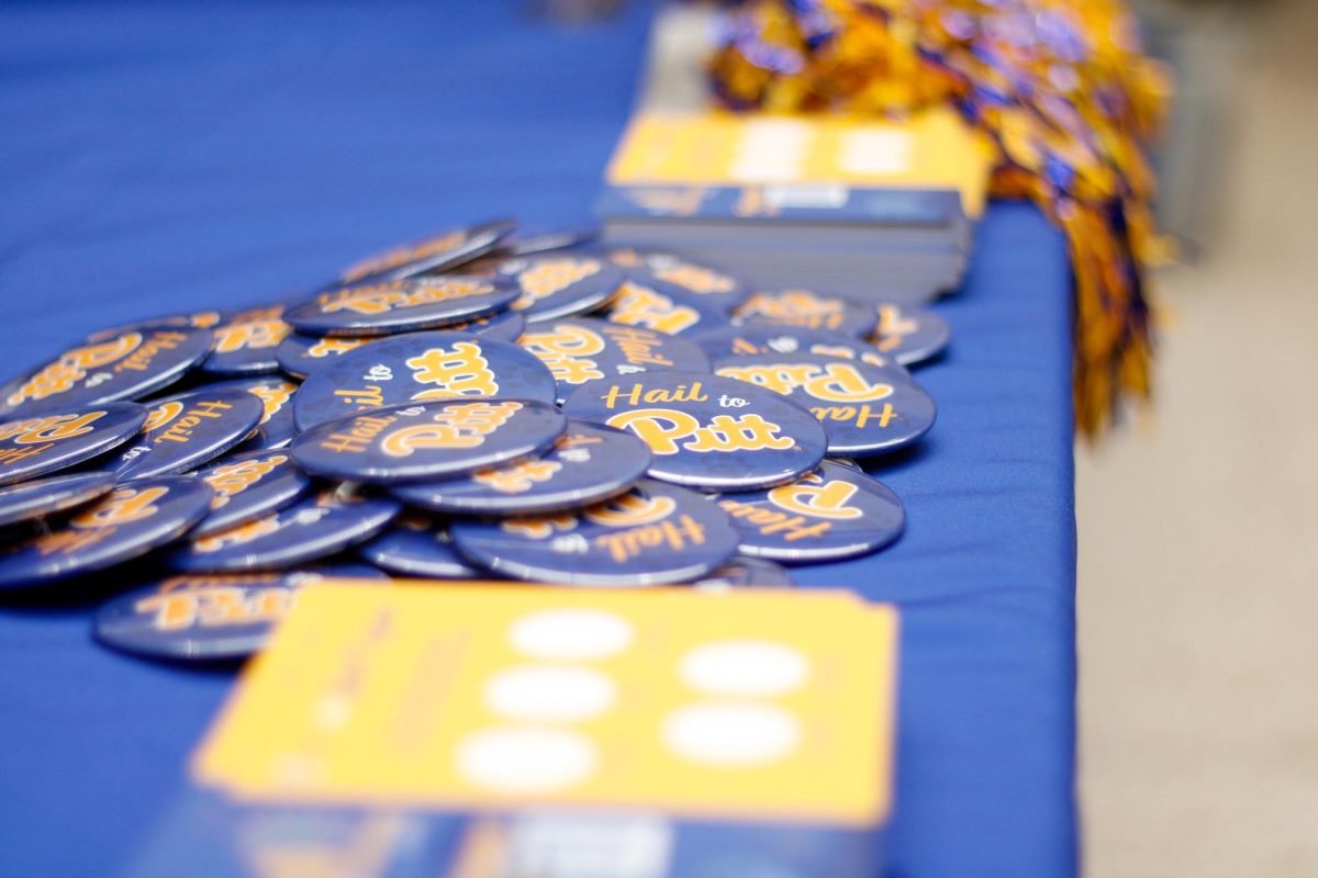 Pins reading “Hail to Pitt” were given out to students attending the homecoming kickoff event on Monday.