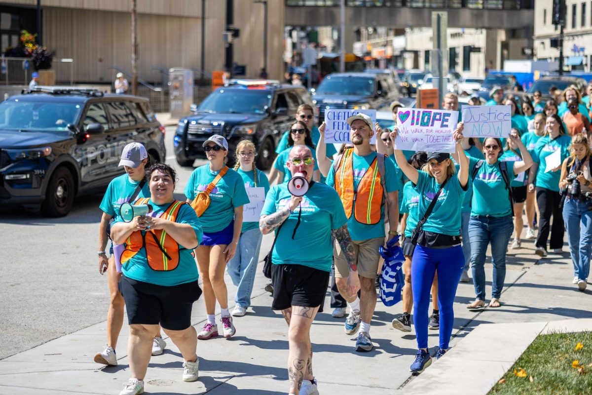 “March for Survivors” participants hold signs and chant as they march down Forbes Avenue on Sunday.
