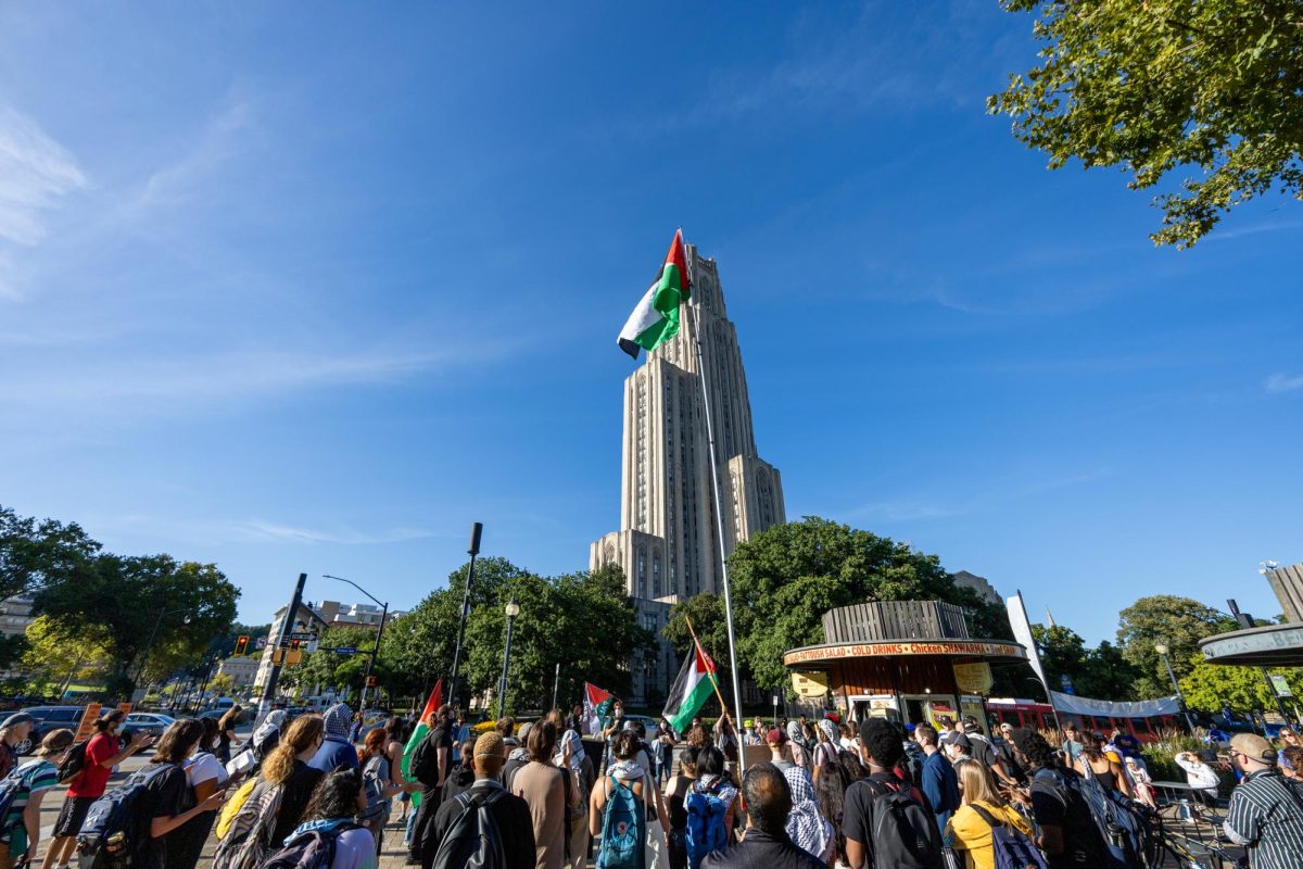 Protestors gather under the Cathedral of Learning during the event at Schenley Plaza on Tuesday.