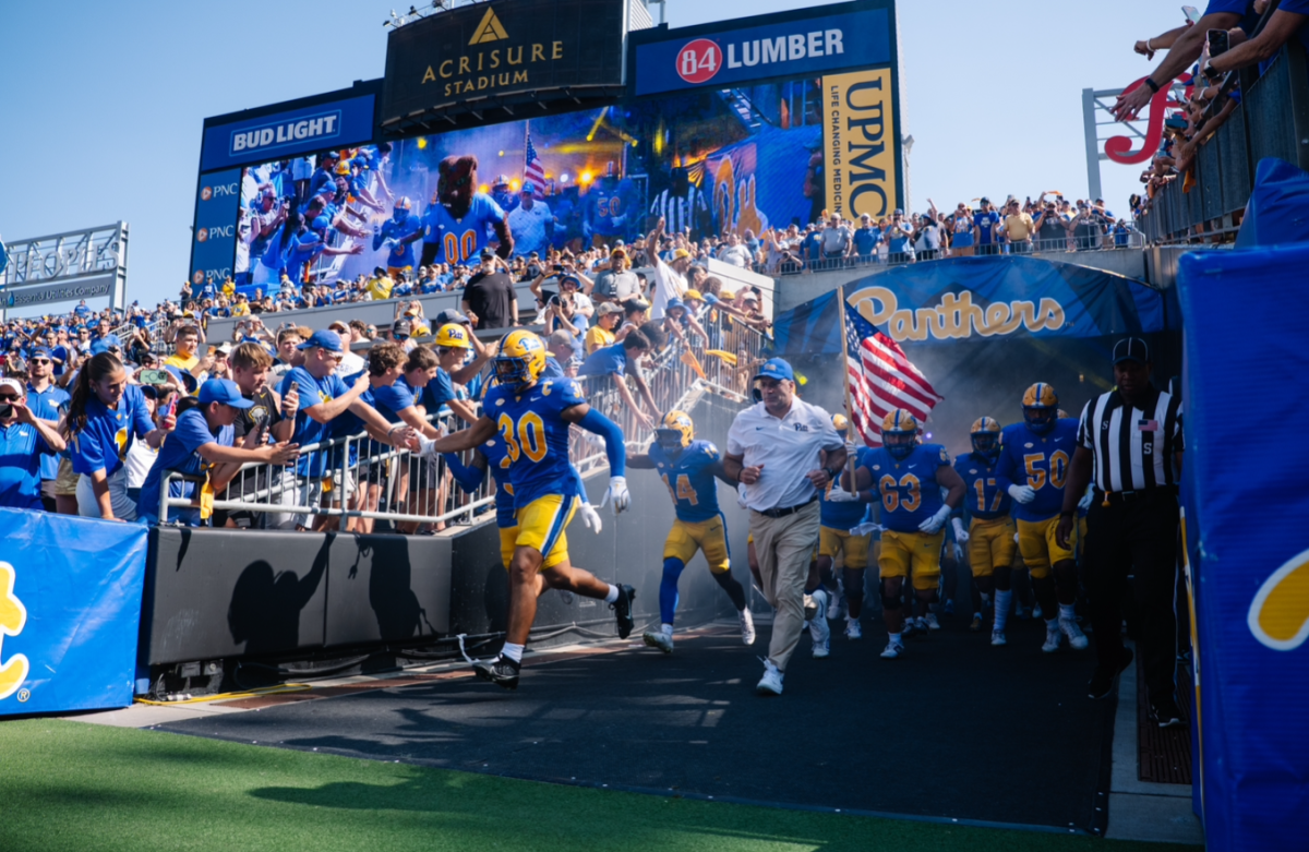 Pitt football runs out onto the field with head coach Pat Narduzzi at Acrisure Stadium.