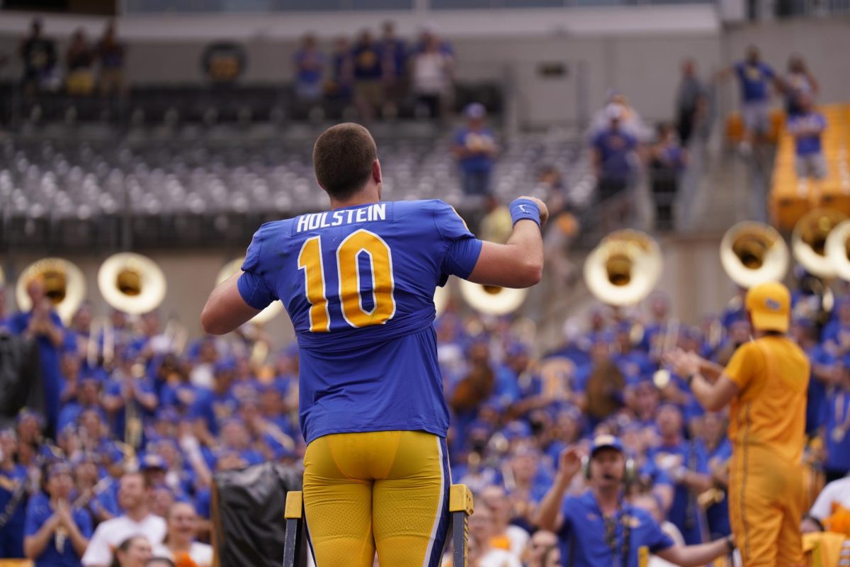 Redshirt first-year quarterback Eli Holstein leads the Pitt band after Pitt football’s victory over Kent State on Saturday, Sept. 2 at Acrisure Stadium.