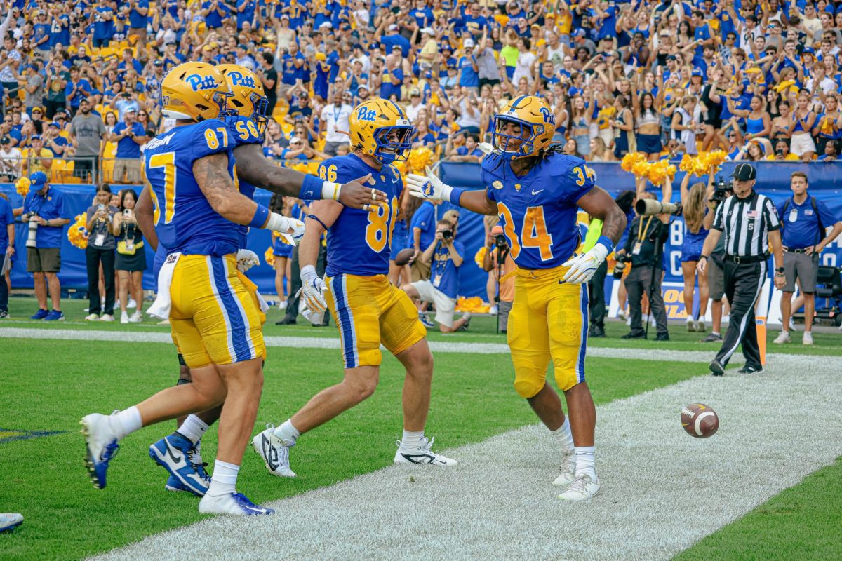 Redshirt junior running back Derrick Davis Jr. (34) celebrates with teammates Moritz Schmoranzer (54), Gavin Bartholomew (86) and Jake Overman (87) after running in a touchdown in the second quarter of Pitt football’s game against Kent State on Saturday at Acrisure Stadium.