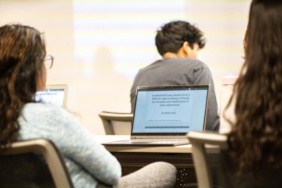 A student takes notes during Social Psych of Reality TV class.