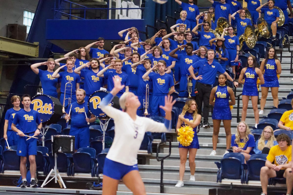 Pitt Band salutes graduate student outside hitter Cat Flood (3) as she prepares to strike the ball at the game against UMBC in the Fitzgerald Field House on Wednesday.