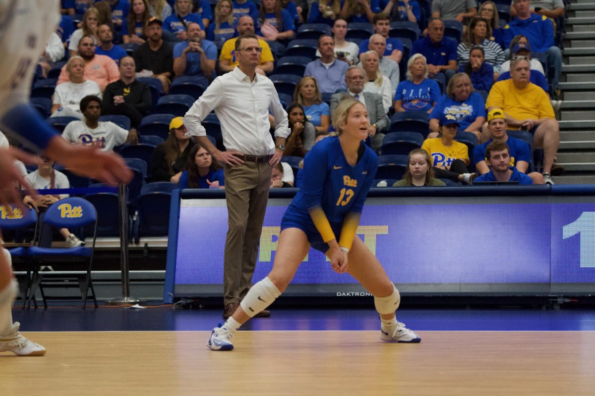 Pitt volleyball’s head coach Dan Fisher observes as first-year libero Mallorie Meyer anticipates the ball at the game against UMBC in the Fitzgerald Field House on Wednesday.