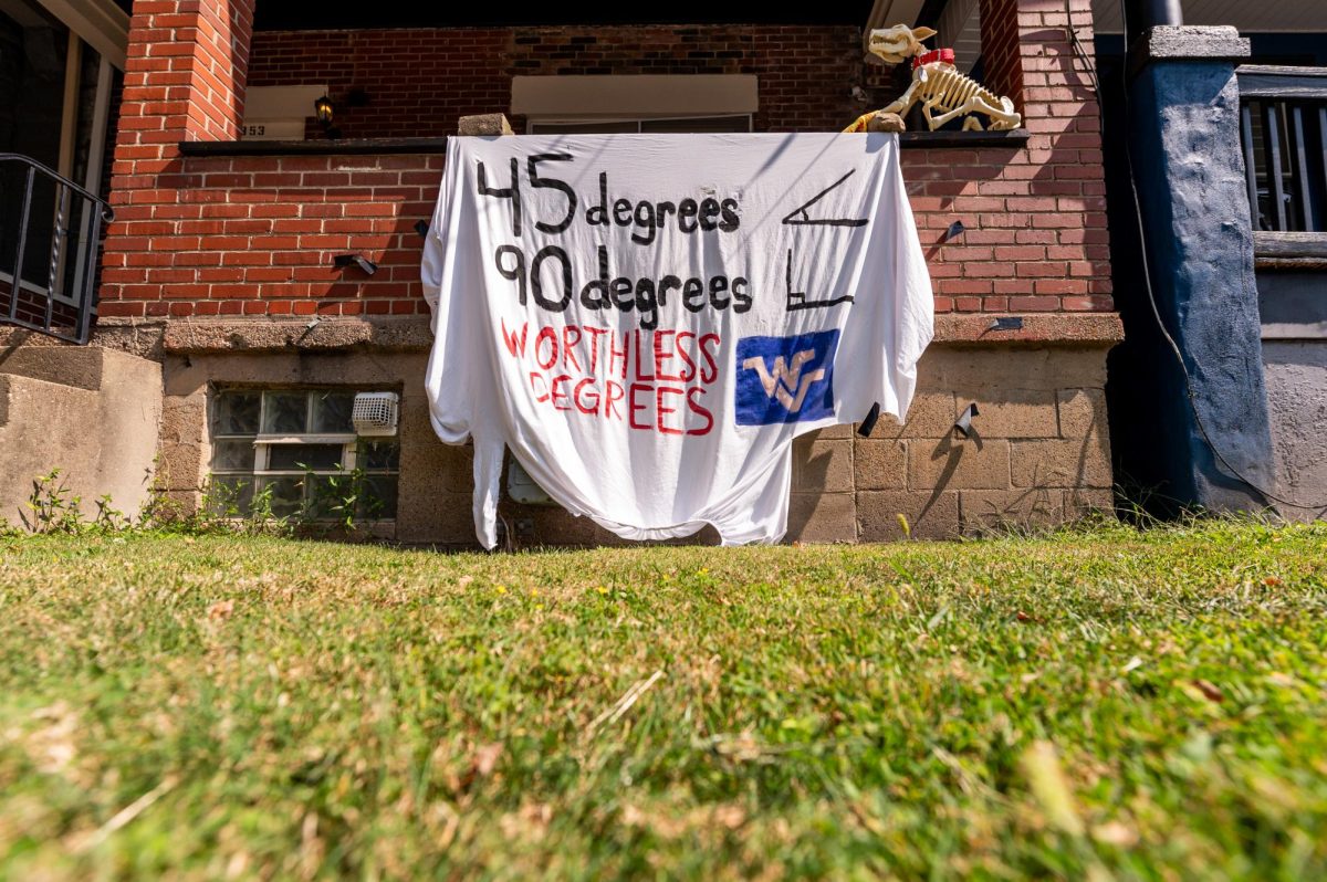 A sheet reading “45 degrees 90 degrees WORTHLESS DEGREES” hangs from a South Oakland home on Friday.