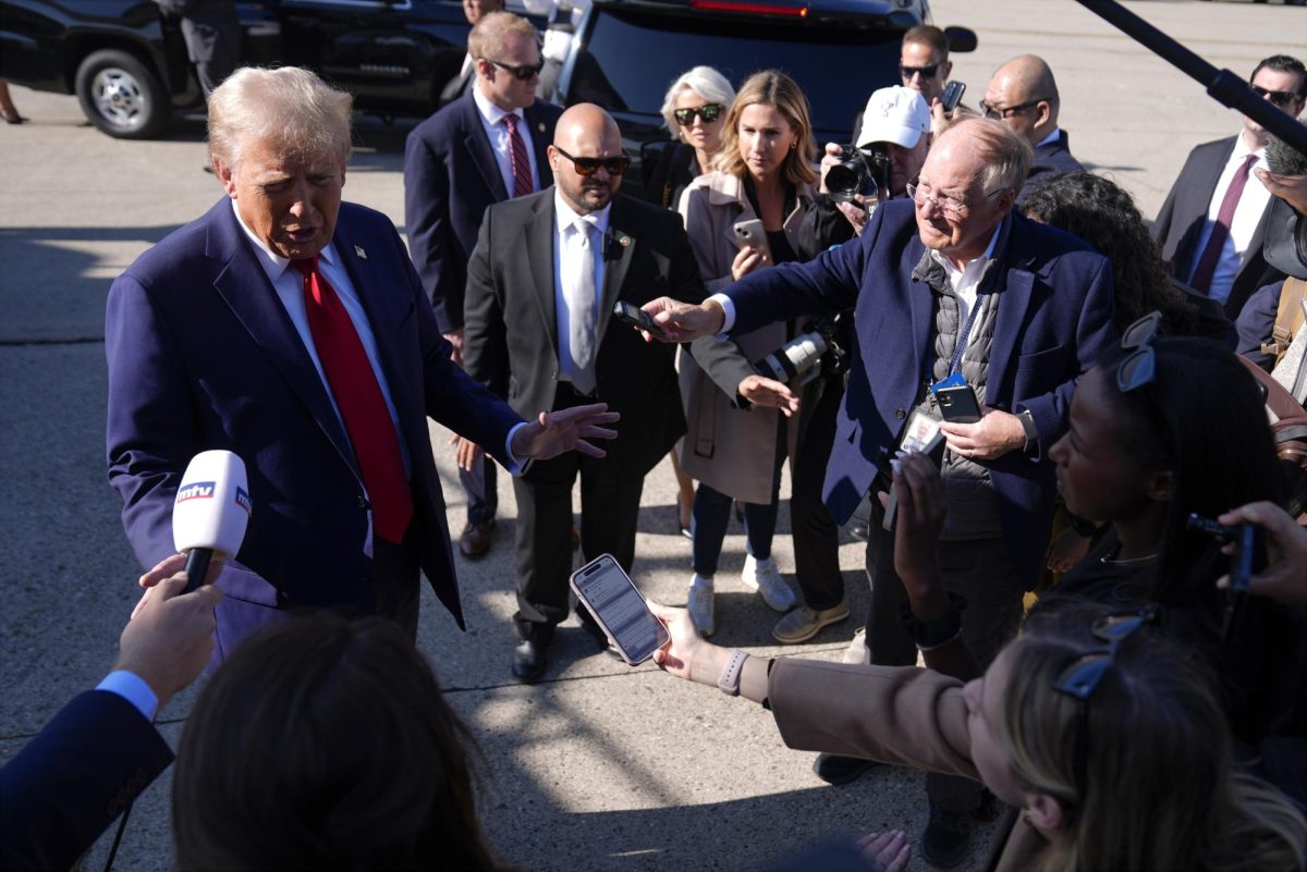 Republican presidential nominee former President Donald Trump speaks to reporters as he arrives at Detroit Metropolitan Wayne County Airport, Friday, Oct. 18, in Detroit.