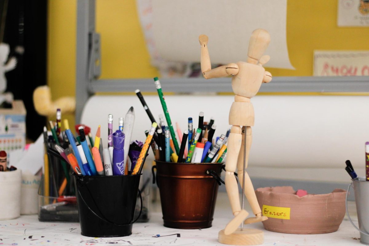 Pens, pencils and a drawing mannequin sit on a table in the Center for Creativity: The Workshop located in the University Store.
