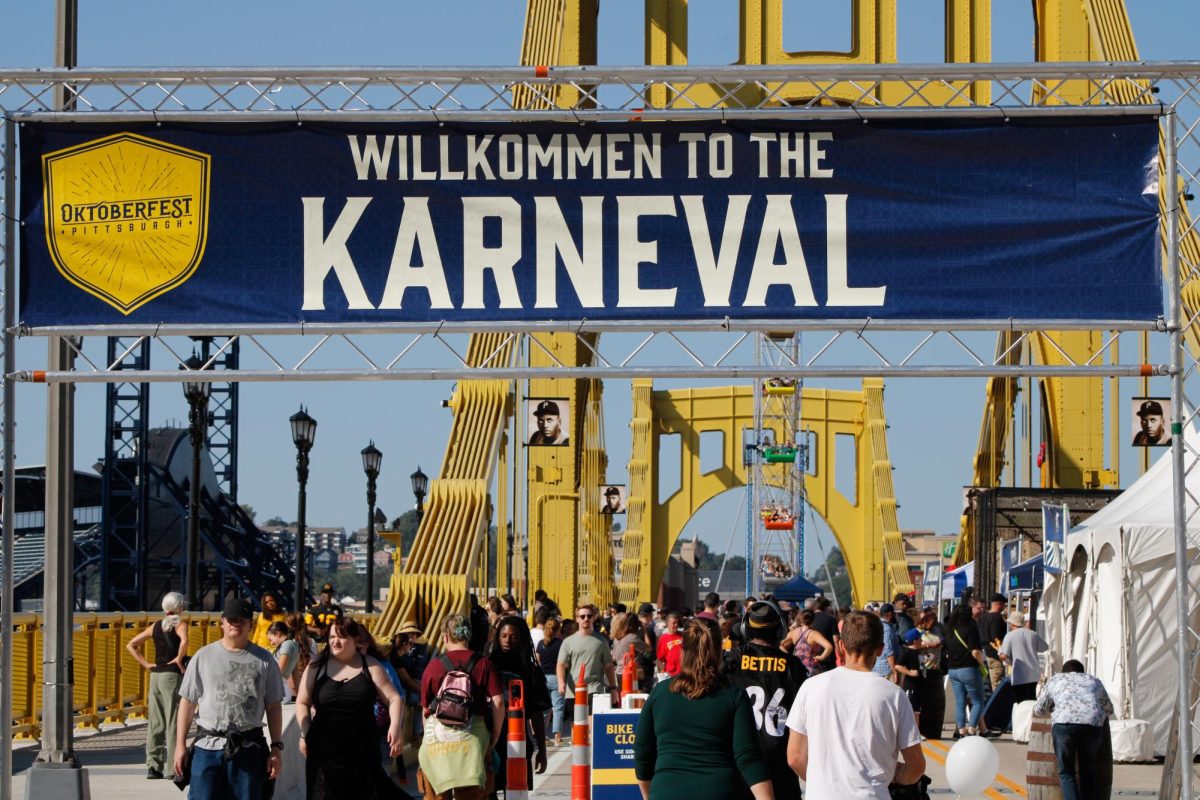 A sign reading “Willkommen to the Karneval” on the Roberto Clemente Bridge welcomes Oktoberfest attendees.
