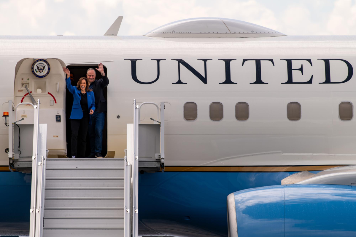 Vice President Kamala Harris and her husband Doug Emhoff wave to a crowd of supporters at Pittsburgh International Airport.
