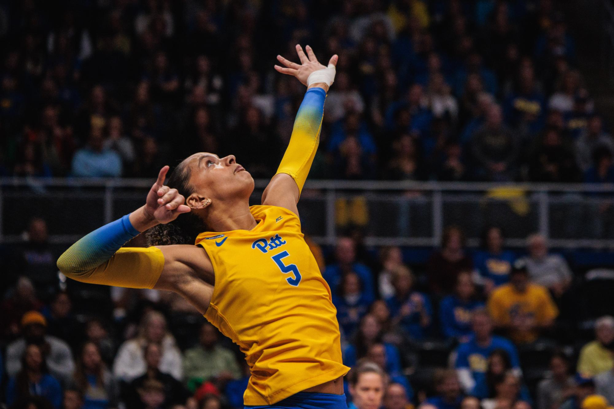 Sophomore right side hitter Olivia Babcock (5) serves the ball during a volleyball match.
