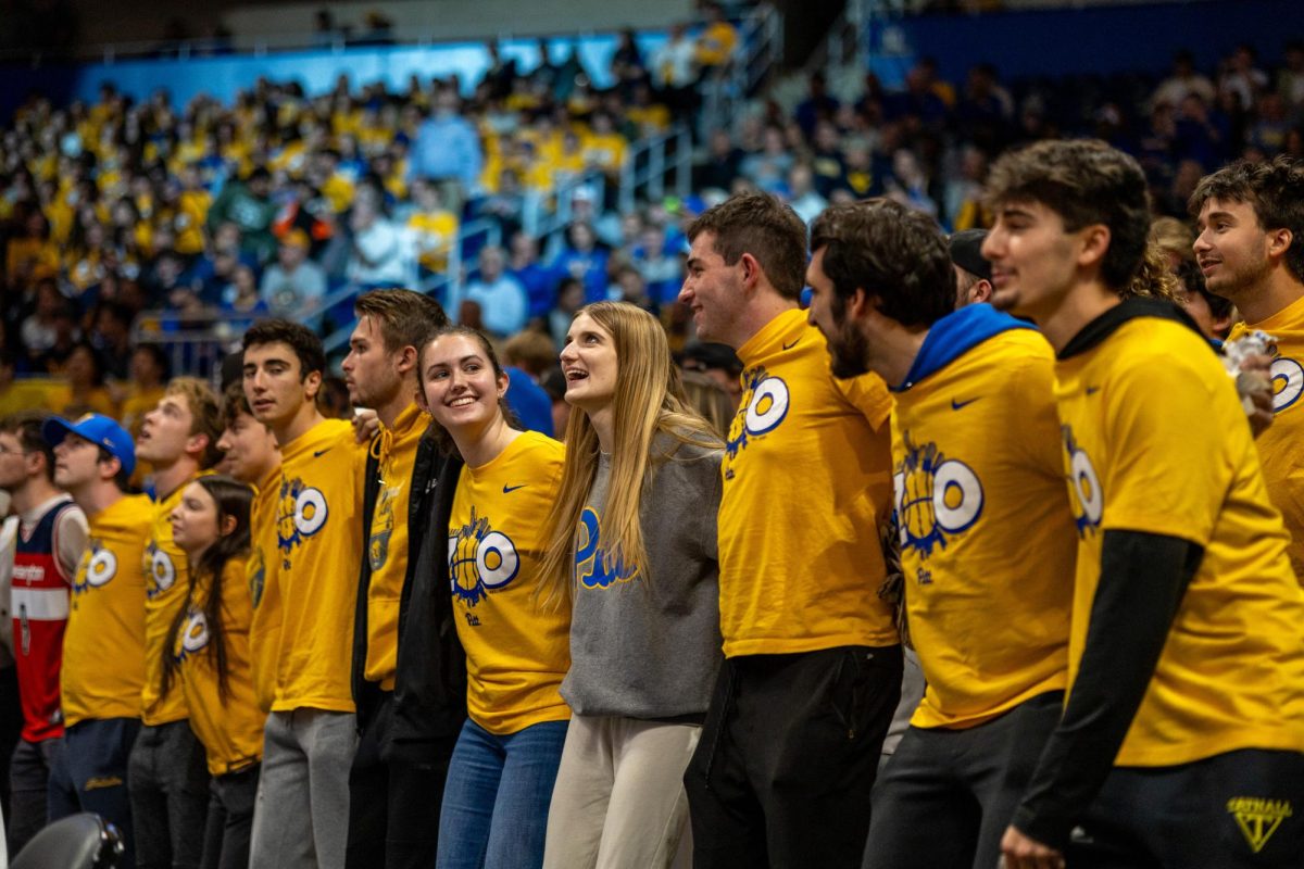 Student of the Oakland Zoo stand together with arms around one another during Pitt basketball's game against West Virginia on Friday, Nov. 15