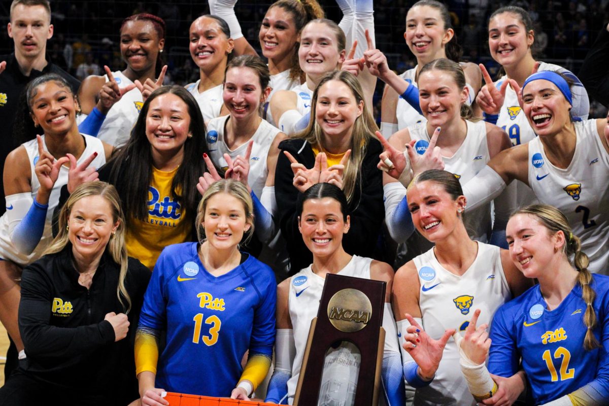 Pitt volleyball celebrates together, holding the regional trophy after its win over Kentucky on Sat. Dec. 14.