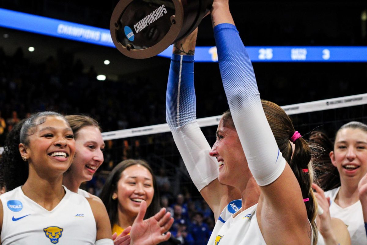 Graduate student libero Cat Flood (3) raises the NCAA regional championship trophy following the quarterfinals of the NCAA tournament on Saturday Dec. 14, 2024 at the Petersen Events Center.